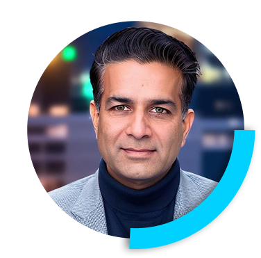 Portrait of Lalit Ahluwalia in a grey jacket and dark turtleneck, inside a circular frame