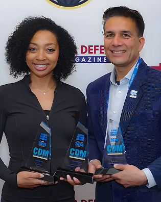 This photo shows two DigitalXForce team members holding Cyber Defense Magazine awards.
